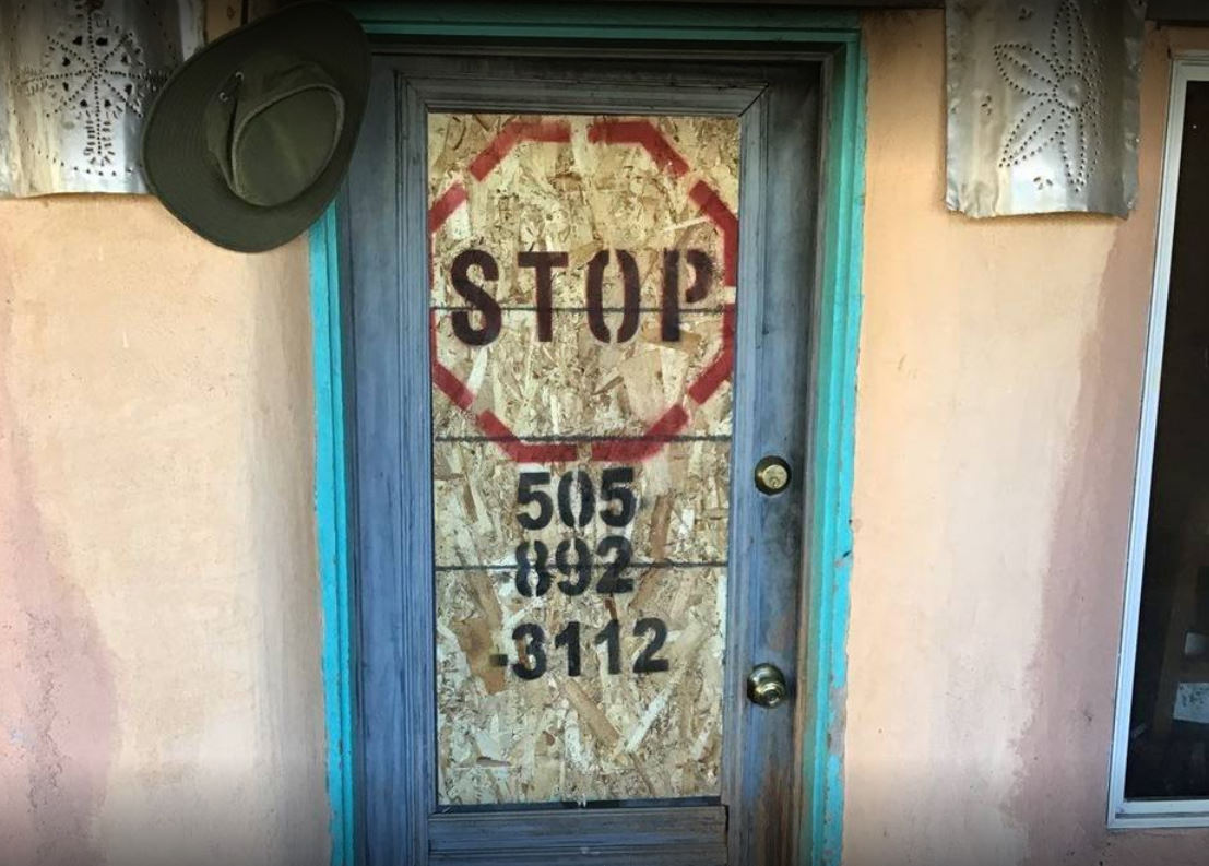 Home Door Boarded Up After Fire Damage