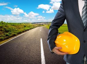 Man in suit holding a hardhat