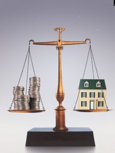 Scale balancing coins and a house 