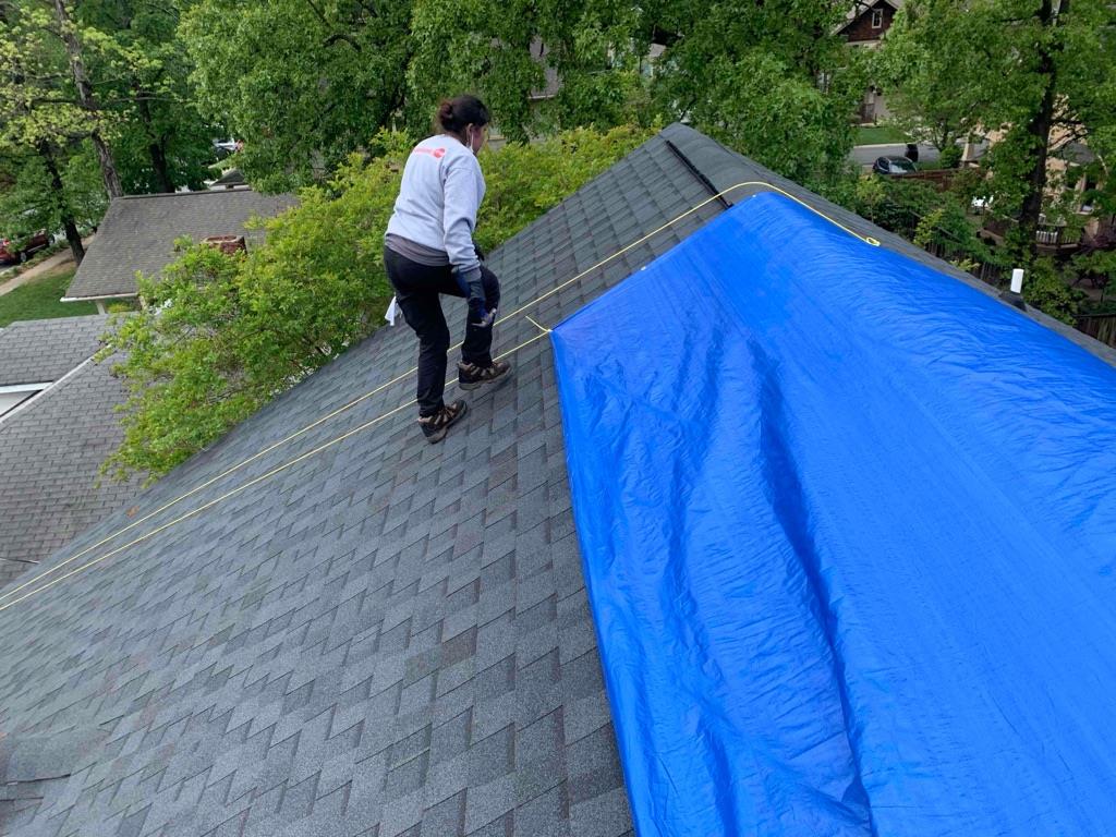 STOP Restoration Professional Putting Tarp on Roof After Storm Damage