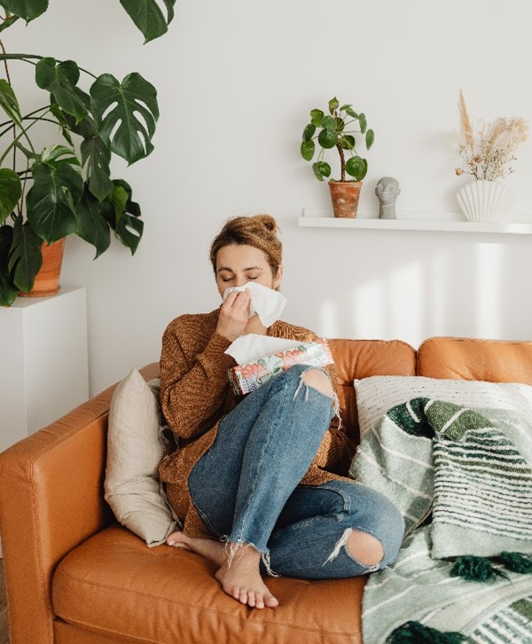 woman sneezing into tissue